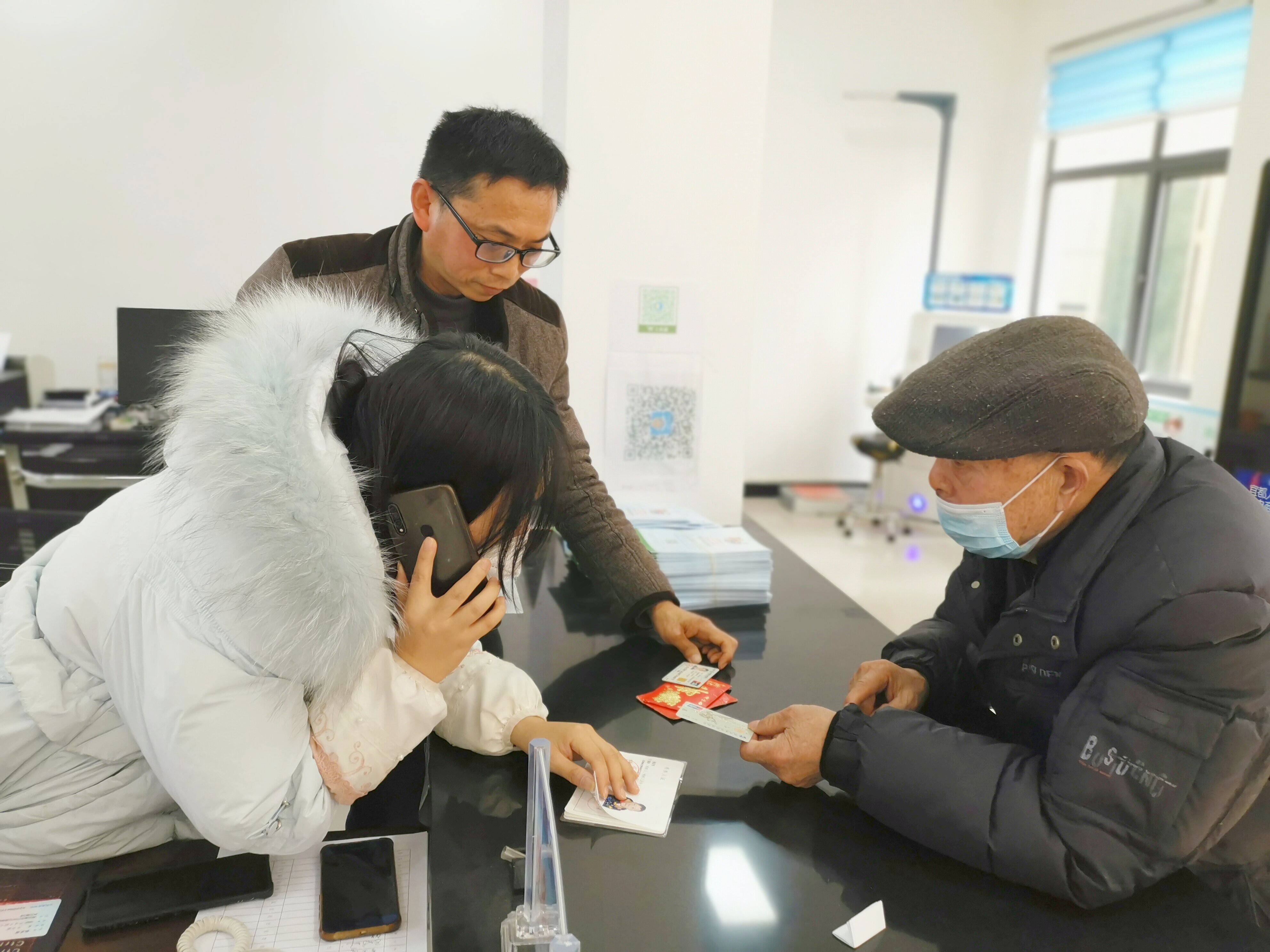 图为陆城街道残联专干孙雪莲与胜利社区残协工作人员张武联系天门市残联，帮助残疾人异地申请“两补”
