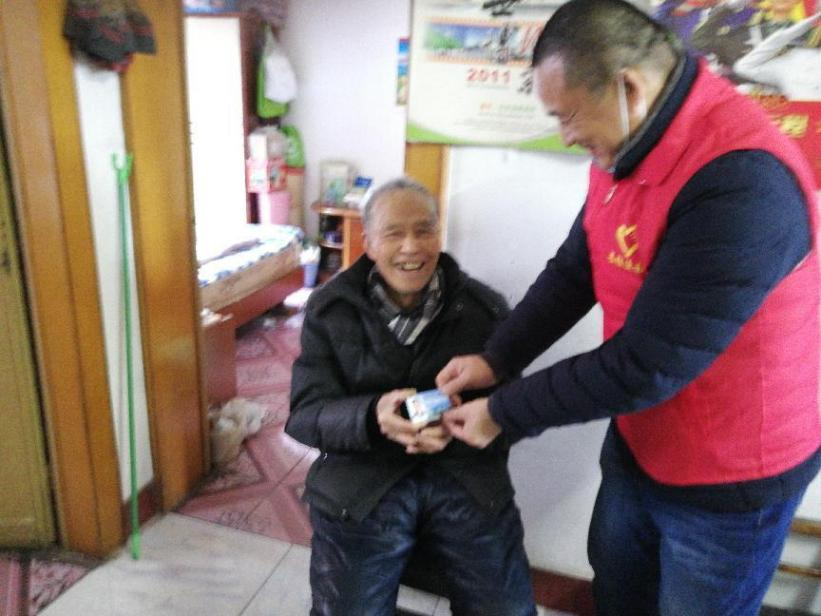 图为残协陈群为残疾人童先生发放优待卡