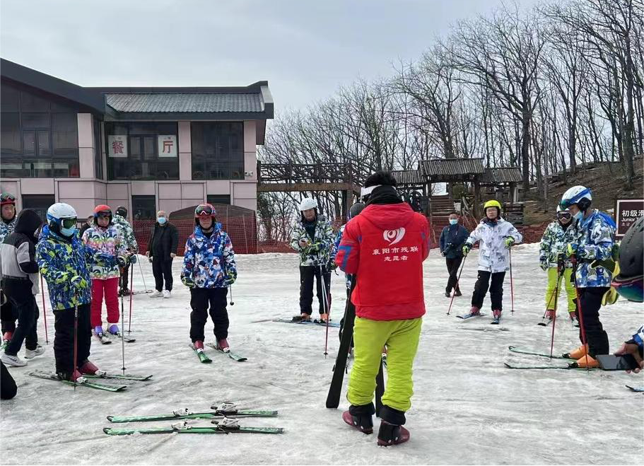 图为志愿者为残疾人运动员讲解滑雪要领